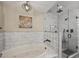 Modern bathroom featuring a soaking tub and a glass-enclosed shower with elegant white and gray tiles at 1422 E Royal Palm Rd, Phoenix, AZ 85020