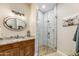 Bright bathroom featuring a wood vanity, granite countertop, and a walk-in shower with glass door at 15218 E San Tan Blvd, Gilbert, AZ 85298
