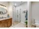 Bright bathroom featuring a wood vanity, granite countertop, and a walk-in shower with glass door at 15218 E San Tan Blvd, Gilbert, AZ 85298