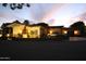 Spacious home exterior with inviting landscaping, warm exterior lighting, and convenient parking at twilight at 15218 E San Tan Blvd, Gilbert, AZ 85298