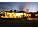 Inviting home exterior with desert landscaping, warm lighting, and a spacious driveway at twilight at 15218 E San Tan Blvd, Gilbert, AZ 85298