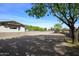 Gravel driveway and a fenced in portion of the property with mature trees at 15218 E San Tan Blvd, Gilbert, AZ 85298