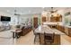 Open-concept living room showcasing a spacious layout with a kitchen island, leather sofa and large windows at 15218 E San Tan Blvd, Gilbert, AZ 85298
