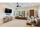 Welcoming living room featuring tiled floors, plantation shutters, a ceiling fan, and a comfortable leather sofa at 15218 E San Tan Blvd, Gilbert, AZ 85298