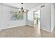 Open dining space with tile flooring and view into bright kitchen, illuminated by modern chandelier at 1684 Leisure World --, Mesa, AZ 85206
