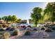 Scenic community pond featuring a fountain, lush landscaping, and clear blue water under a bright sky at 16902 W Marcos De Niza Dr, Surprise, AZ 85387