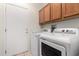 Convenient laundry room features a modern washer and dryer with overhead cabinet storage at 16902 W Marcos De Niza Dr, Surprise, AZ 85387