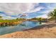 Scenic pond with rock edging reflects the blue sky, creating a tranquil setting at 16902 W Marcos De Niza Dr, Surprise, AZ 85387