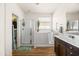 Bright bathroom featuring a walk-in shower, walk-in bathtub, and a dark wood vanity at 1705 W Stephanie Ln, San Tan Valley, AZ 85144
