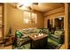 Cozy covered patio with a fireplace, plush seating, and a ceiling fan for year-round enjoyment at 1705 W Stephanie Ln, San Tan Valley, AZ 85144