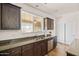 Well-maintained kitchen featuring a stainless steel dishwasher, double sink, and granite countertops at 1705 W Stephanie Ln, San Tan Valley, AZ 85144