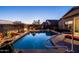 Sparkling pool illuminated at dusk, surrounded by beautiful desert landscaping, for serene outdoor living at 1705 W Stephanie Ln, San Tan Valley, AZ 85144