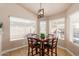 Bright breakfast nook with a wooden table, four chairs, and a view through the window at 1750 N Abner --, Mesa, AZ 85205