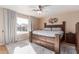 Cozy bedroom featuring a wooden bed frame, ceiling fan, and natural light from a large window at 1750 N Abner --, Mesa, AZ 85205