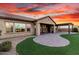 A seamlessly landscaped lawn merges with a vast brick patio, creating an outdoor area for entertaining and relaxation at 21647 S 223Rd Pl, Queen Creek, AZ 85142