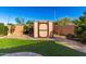 A backyard featuring a storage shed, green lawn, and brick-paved border offering both functionality and aesthetic appeal at 21647 S 223Rd Pl, Queen Creek, AZ 85142
