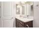 Bathroom featuring a single vanity, a decorative mirror, and a dark-wood cabinet with a white door at 21647 S 223Rd Pl, Queen Creek, AZ 85142