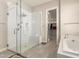 Bright bathroom featuring a glass shower with a built-in seat and a separate soaking tub at 21647 S 223Rd Pl, Queen Creek, AZ 85142