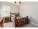 Bedroom with wooden bed frame, plaid comforter, and a nightstand with a lamp at 21647 S 223Rd Pl, Queen Creek, AZ 85142