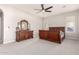 Large bedroom with carpet flooring, ceiling fan, and dresser with decorative mirror at 21647 S 223Rd Pl, Queen Creek, AZ 85142