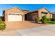 Charming single-story home featuring a brick exterior, three-car garage, and a beautifully paved driveway at 21647 S 223Rd Pl, Queen Creek, AZ 85142