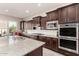 This kitchen features an island with granite countertop, stainless appliances, and wood cabinets at 21647 S 223Rd Pl, Queen Creek, AZ 85142