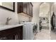 Bright laundry room featuring modern washer/dryer, sink, and storage cabinets for efficient organization at 21647 S 223Rd Pl, Queen Creek, AZ 85142