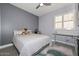 Comfortable bedroom with a gray accent wall, wood-look tile flooring, and a ceiling fan at 29674 N 127Th Ln, Peoria, AZ 85383