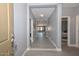 Bright hallway featuring neutral gray tones and modern flooring, leading to various rooms within the home, and lots of space at 29674 N 127Th Ln, Peoria, AZ 85383