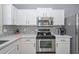The kitchen showcases stainless steel appliances, white cabinetry and a stylish backsplash design at 29674 N 127Th Ln, Peoria, AZ 85383