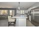 Spacious kitchen with a center island, pendant lighting, stainless steel appliances, and wood-look tile flooring at 29674 N 127Th Ln, Peoria, AZ 85383
