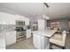 Beautiful kitchen features white cabinets, stainless steel appliances, a tile backsplash, and island with seating at 29674 N 127Th Ln, Peoria, AZ 85383