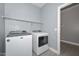 Laundry room featuring modern appliances, ample shelving, and tiled floors at 29674 N 127Th Ln, Peoria, AZ 85383