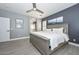 This gray-toned bedroom includes a king-sized bed, a ceiling fan and an ensuite bathroom at 29674 N 127Th Ln, Peoria, AZ 85383