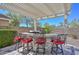 Outdoor kitchen with stone counter, grill, bar seating, and pergola for dining and entertaining al fresco at 29674 N 127Th Ln, Peoria, AZ 85383