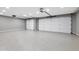 Spacious three car garage with epoxy flooring and two white overhead doors at 3005 W Donatello Dr, Phoenix, AZ 85086