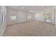 Open-concept living room with neutral carpeting, natural light, and an archway to the kitchen at 3005 W Donatello Dr, Phoenix, AZ 85086