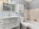Charming bathroom featuring a white vanity with drawers, medicine cabinet, toilet, and tub with tile surround at 3727 W Gardenia Ave, Phoenix, AZ 85051