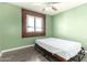 Green bedroom with natural light from the window and simple bed frame, providing a fresh feel at 3727 W Gardenia Ave, Phoenix, AZ 85051