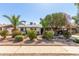 Charming home with rock landscaping, vibrant flower bushes, well maintained green shrubs, and mature shade trees in the front yard at 3727 W Gardenia Ave, Phoenix, AZ 85051
