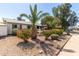 Charming home featuring rock landscaping, flowering bushes, shade trees, and mature palms in the well-manicured front yard at 3727 W Gardenia Ave, Phoenix, AZ 85051
