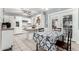 Bright kitchen with white cabinetry, tile backsplash, a breakfast bar, and an adjacent dining area at 3727 W Gardenia Ave, Phoenix, AZ 85051