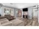 Comfortable living room with a large couch, shuttered glass doors, modern flooring, and a wall-mounted television at 3727 W Gardenia Ave, Phoenix, AZ 85051
