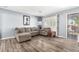 Comfortable living room with neutral-toned furniture, a decorative horse print, shuttered doors, and wood-look flooring at 3727 W Gardenia Ave, Phoenix, AZ 85051