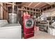 A utility room featuring a red washer, white dryer, water heater, shelving, and storage items at 3727 W Gardenia Ave, Phoenix, AZ 85051