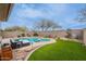 Backyard oasis featuring a sparkling pool, patio area, lush artificial lawn, and privacy landscaping at 42711 N 43Rd Dr, New River, AZ 85087
