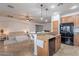 Modern kitchen with a central island, stainless steel appliances, and seamless flow into the living room, ideal for entertaining at 42711 N 43Rd Dr, New River, AZ 85087