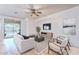 Bright living room featuring a ceiling fan and sliding glass doors to backyard pool at 42711 N 43Rd Dr, New River, AZ 85087