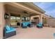 Covered patio featuring ample seating, outdoor dining, a built-in grill, and a view of the pool at 42711 N 43Rd Dr, New River, AZ 85087