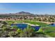 Scenic aerial view of the golf course community with lush greenery, water feature, and mountain backdrop at 4325 E Vallejo Ct, Gilbert, AZ 85298